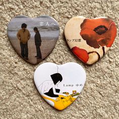 three heart shaped magnets with pictures of two people on the beach and one is holding a guitar picker