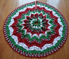 a crocheted christmas ornament is shown on the floor in red, green and white