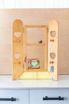 an open door to a wooden jewelry box on top of a white counter next to drawers