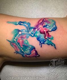 a colorful tattoo on the arm of a woman with stars and planets painted on it