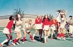 a group of young women standing next to each other on top of a tennis court