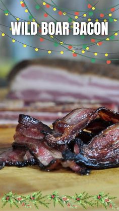 some bacon on a wooden cutting board with christmas lights in the background and text overlay that reads wild boar bacon