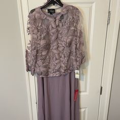 a dress hanging on a hanger in front of a door