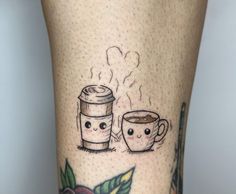 two coffee mugs with faces drawn on them are sitting next to each other in front of the legs