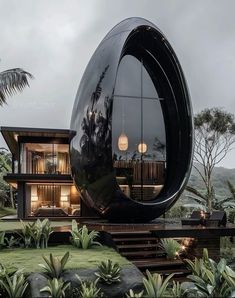 an unusual house in the middle of a lush green field