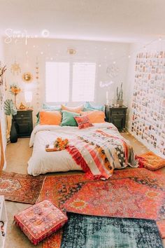 a bed with lots of pillows on top of it in a room filled with rugs