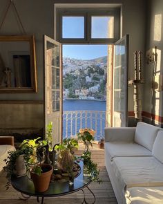 a living room filled with furniture and a large window overlooking the water's edge