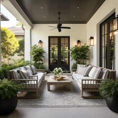 an outdoor living area with couches, tables and potted plants