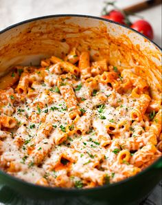 a green pot filled with macaroni and cheese covered in parmesan sauce