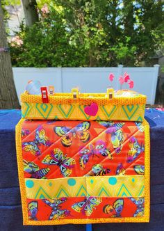 an orange and yellow purse sitting on top of a blue table