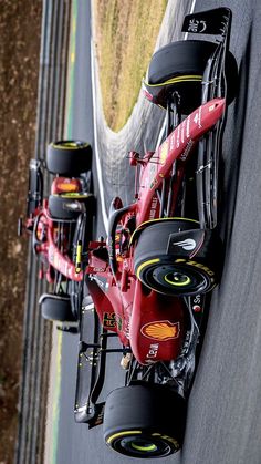 two racing cars driving on a race track with one being pushed by the other side