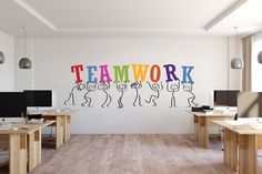 an office with two desks and three computer screens on the wall that say teamwork