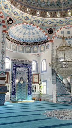 the interior of a large building with blue and white tiles on the ceiling, chandeliers and windows