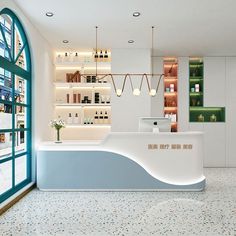 a white counter in a store with lots of bottles on the wall and shelves behind it