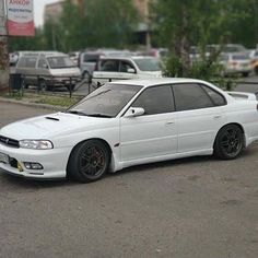 a white car is parked on the street