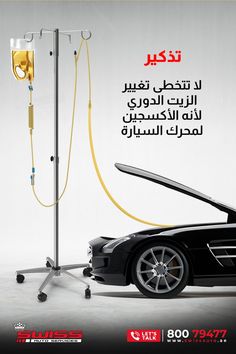 a black car is hooked up to a pole with a yellow hose connected to it