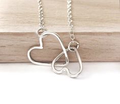 What a perfect delicate necklace. This minimalist necklace is perfect alone or layered with other necklaces. Make the perfect gift to yourself or to a loved one for any occasion. DETAILS - This is a necklace of two small interlinked silver hearts made by 1mm sterling silver wire, shaped, soldered and finished by hand. It has been sanded and polished to give it a shinny look. It is attached on a sterling silver dainty chain with sterling silver spring clasp, the total length of chain includes the Minimalist Nickel-free Heart Pendant Necklace, Minimalist Nickel-free Necklace For Valentine's Day, Minimalist Adjustable Heart Necklace, Everyday Heart-shaped Nickel-free Necklaces, Nickel-free Heart Necklace For Everyday Wear, Everyday Heart Shaped Nickel Free Necklace, Everyday Nickel-free Heart Shaped Necklaces, Everyday Heart-shaped Nickel-free Necklace, Minimalist Adjustable Heart Charm Necklaces