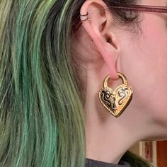 a close up of a person with green hair and wearing some kind of earring