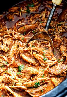 the food is being cooked in the crock pot with a ladle on it