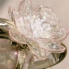 a clear glass flower sitting on top of a mirror