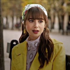 a woman with long hair wearing a yellow jacket