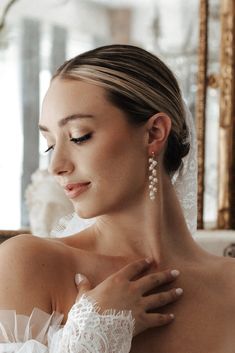 a woman in a wedding dress with her hands on her chest