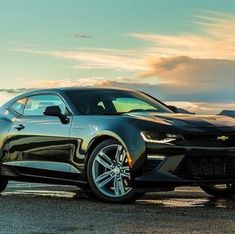 a black chevrolet camaro is parked on the road