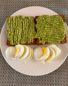 a white plate topped with two slices of toast and eggs next to an egg yogurt