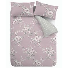 a bed with pink flowers and polka dots on the pillowcase, along with two pillows