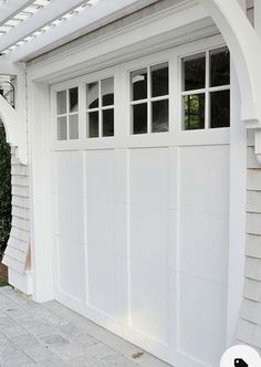 a white garage door with an arch over the top and side windows on one side