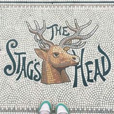 someone standing in front of a mosaic floor with the words, the stag's head on it