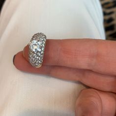 a close up of a person's hand with a diamond ring on their finger