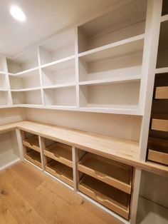 empty white shelves in a room with wood flooring