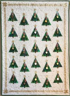 a quilted wall hanging with christmas trees on it