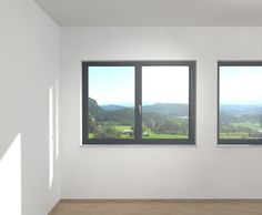 an empty room with three windows overlooking the mountains