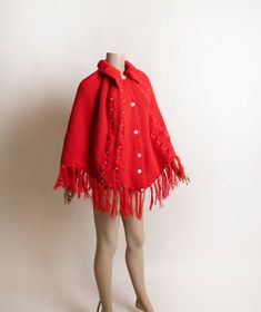 FREE DOMESTIC SHIPPING! <3♥ Bright & cheery red knit poncho with a fringe hem!♥ Buttons up the front, folded large collar! ♥ White accents in the cable-like knit! ♥ In great condition! No label tags. * measurements *About 26" across the bust areaLength - 21" with a 5" fringe on the bottom (so 26" in total)** I do ship worldwide!For more vintage cuteness, check out my store:→ http://zwzzy.etsy.com ←❀ Instagram - Zwzzy❀ Twitter - http://www.twitter.com/zwzzy❀ Facebook - http://www.facebook. Red Long Sleeve Poncho, One Size, Red One-size Poncho Cape, Red One-size Cape Poncho, Red Knit Outerwear With Buttons, Red One Size Cape Poncho, Red Cozy Acrylic Outerwear, Red Knitted Outerwear, Red Knitted One Size Sweater, One Size Red Knitted Outerwear