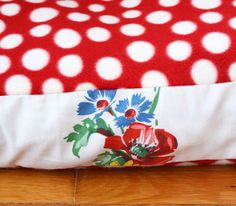 a red and white polka dot pillow with flowers on it