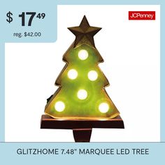 a green lighted christmas tree with white lights on it's base and the words glithome 74th marquee led tree