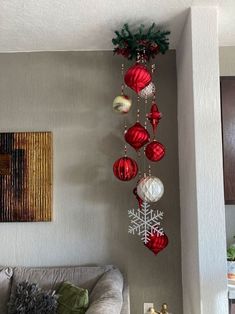 a living room decorated for christmas with ornaments hanging from the ceiling and decorations on the wall