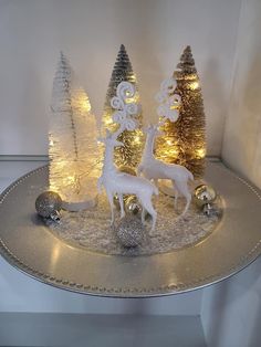 a silver tray topped with christmas trees and reindeer figurines