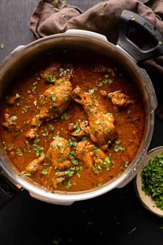 a pan filled with chicken curry and garnished with parsley