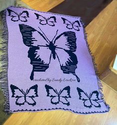 a purple and black butterfly afghan on a table