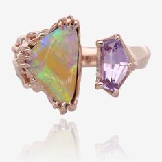 Utterly unparalleled and unique! This colorful ring features a two carat Queensland opal with ribbons of lavender, yellow, green, and orange. Set in a triple claw prong mounting, the prongs then curl and loop into the vine pattern band. Opposite this opal is a stunning step cut trapezoid sapphire in a luscious lavender color. Sapphire weighs 0.90 carat and is sourced from a fair trade owner-operator Umba Valley mine in Tanzania. It is set in a sleek five prong mounting that flows smoothly into a knife-edge band echoing the stone's planes and angles.  Crafted in solid 14k rose gold, this ring is a juxtaposition of organic and sleek, open on top to showcase the contrasting designs. The opal measures 12.2 x 8mm, weighs 2cts, was mined and cut by a woman-owned operation. The natural sapphire w Opal And Sapphire Ring, Colorful Ring, Rose Gold Gifts, Vine Pattern, Claw Prong, Step Cut, 14k Rose Gold Ring, Purple Band, Gem Ring