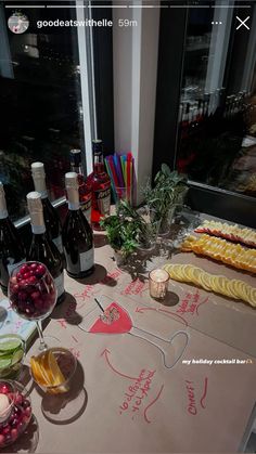 a table topped with lots of bottles of wine next to fruit and veggies