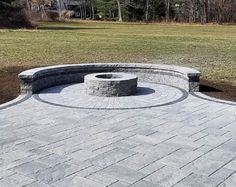 an outdoor fire pit surrounded by brick pavers