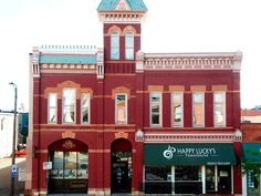 an old red brick building with a clock tower on the front and side of it