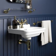 a white sink sitting under a bathroom mirror next to a wall mounted faucet