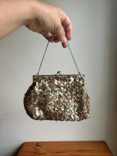 Small vintage evening purse with a short chain. Please see photos of the clasp as some of the finish has worn off. The finish on a lot of the sequins has also worn off. The inside of the bag is in good condition.  ♻️ Please note: I try to reuse shipping materials when I have them available. ♻️  *I pack all of my items extremely carefully. I also have insurance through the post office for the items I ship. In the unlikely event that an item arrives damaged the buyer agrees to hold the item and ta Vintage Evening Coin Purse Pouch, Vintage Handheld Evening Bag For Party, Gold Sequined Evening Bag For Parties, Vintage Clutch Evening Bag For Events, Glamorous Gold Sequined Clutch, Vintage Pouch Coin Purse For Party, Sequin Clutch Evening Bag For Formal Occasions, Gold Sequined Evening Bag For Events, Gold Sequin Clutch For Events