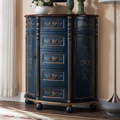 an ornate blue cabinet with flowers on top