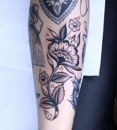 a woman's arm with tattoos on it and flowers in the middle of her arm